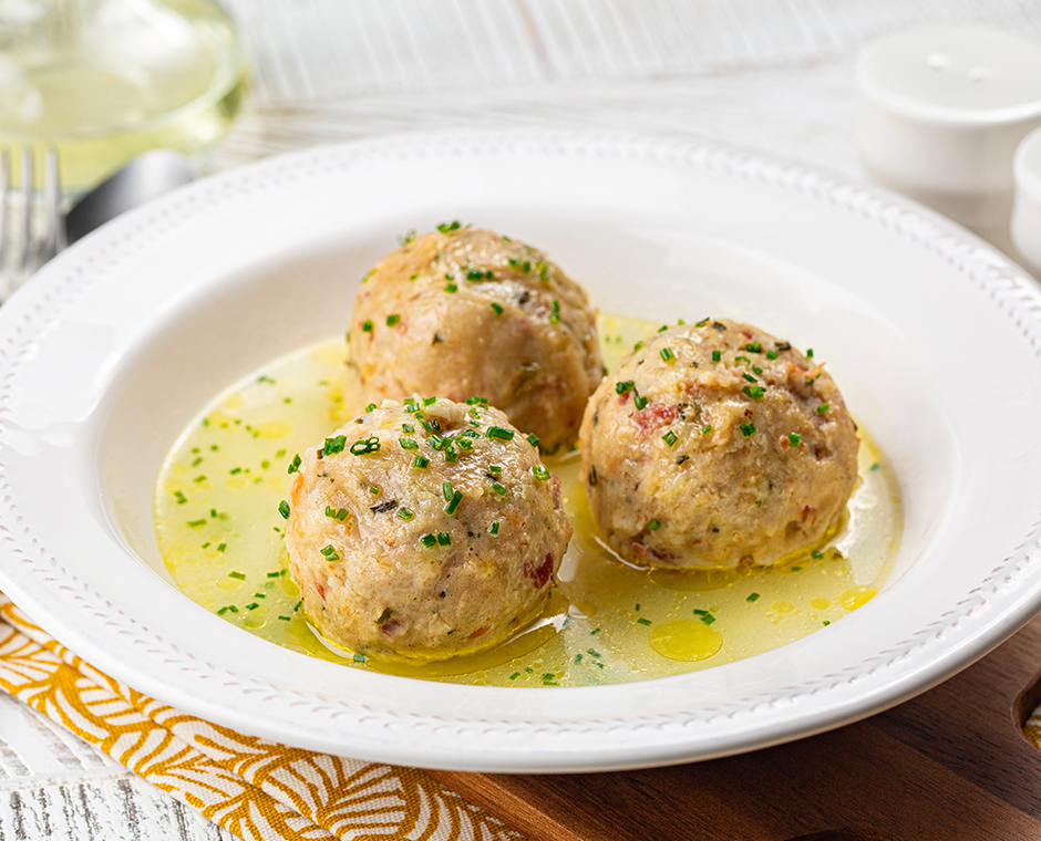 Canederli o Knödel in brodo con cipolla verde, pasta o canederli tipici della cucina alpina, altoatesina, tedesca, italiana, austriaca.