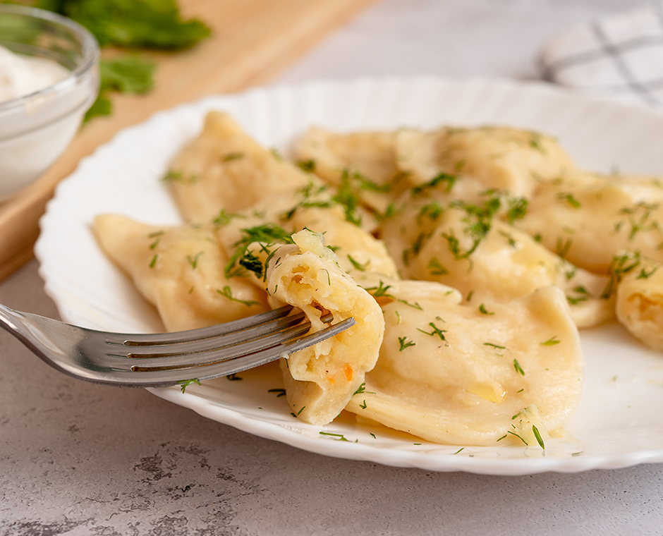 Gnocchi di patate cosparsi di aneto su un piatto bianco.