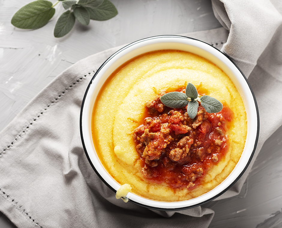 Un piatto con polenta con pomodoro e ragu di cervo