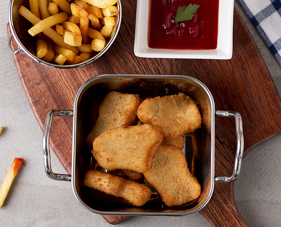 Nuggets di pollo con patatine fritte salsa chili servito in piatto