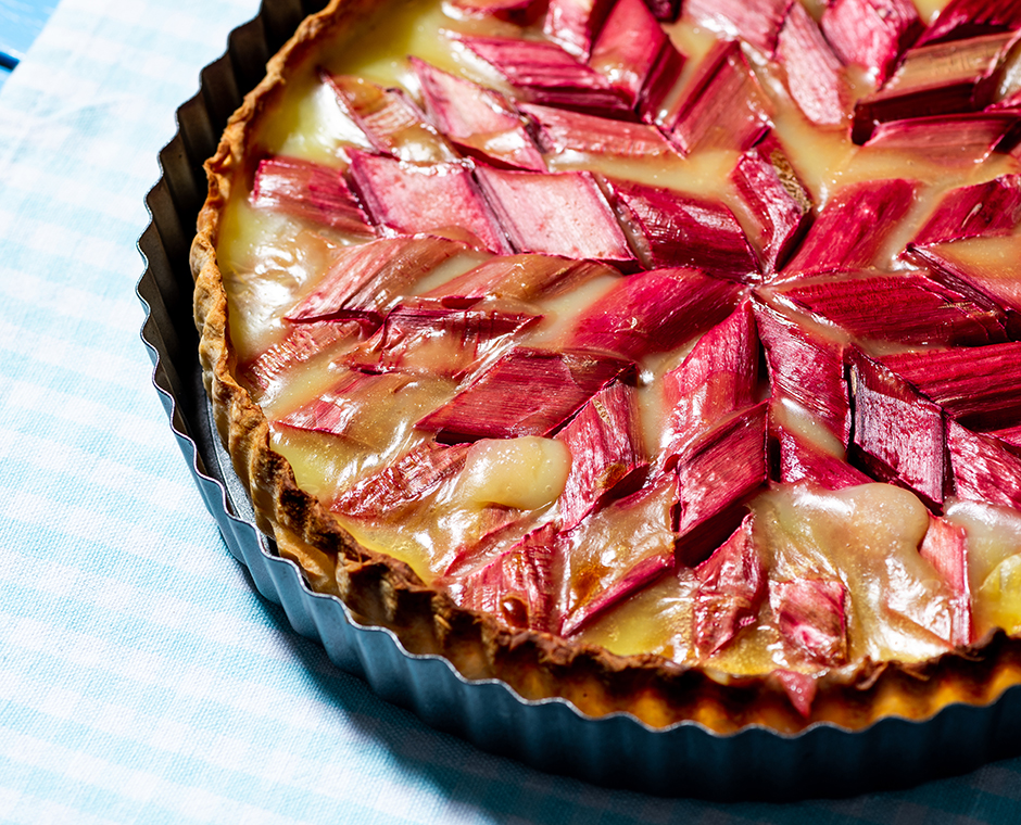 Torta dolce di rabarbaro fatta in casa su tavolo da giardino in legno.