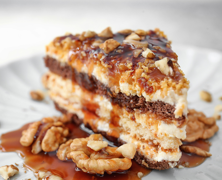 Piatto con pezzo di deliziosa torta al caramello e noci sul tavolo